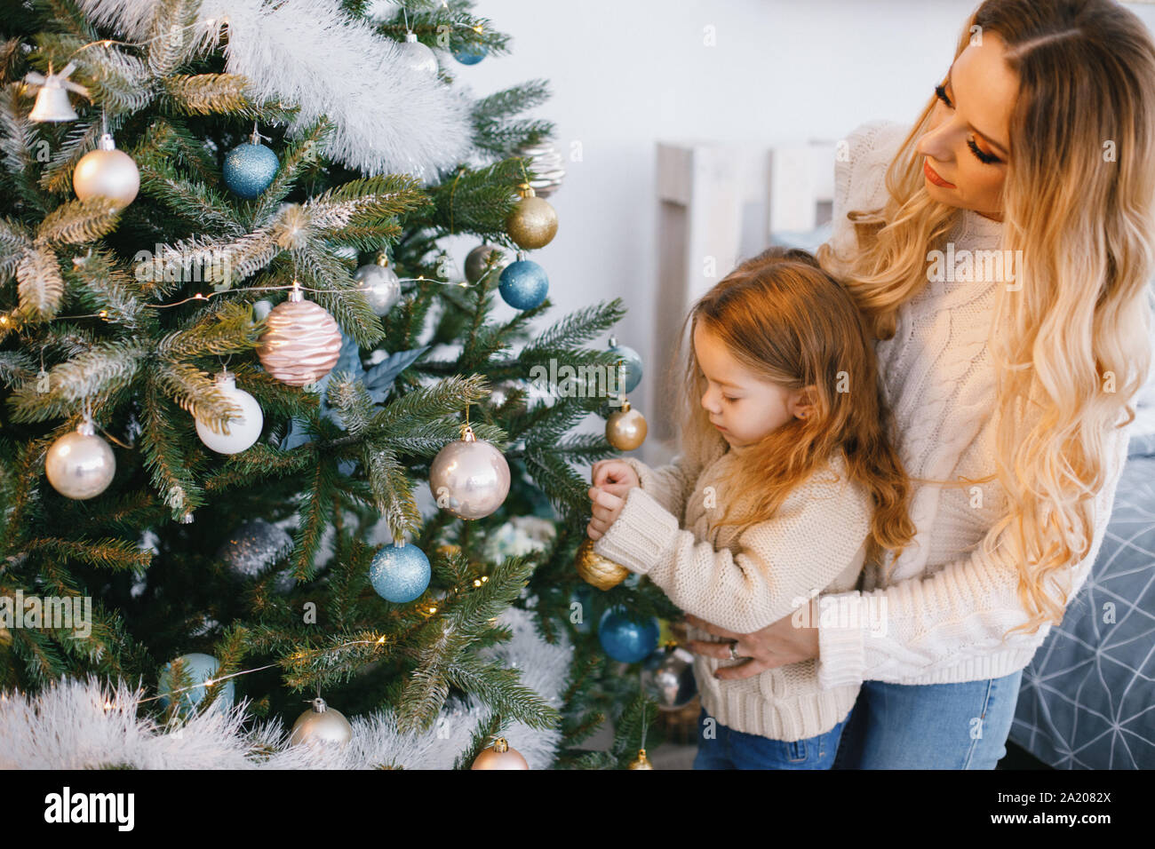 Madre e figlia decorare l'albero Foto Stock