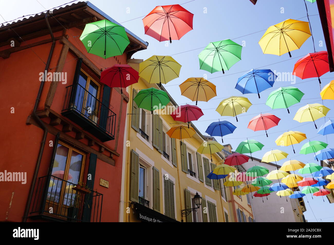 Colorate e luminose ombrelloni appesi in strada di Gap, Francia su una giornata di caduta Foto Stock