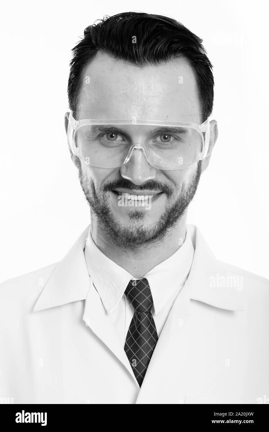 Volto del giovane uomo felice medico sorridere mentre indossa gli occhiali di protezione Foto Stock