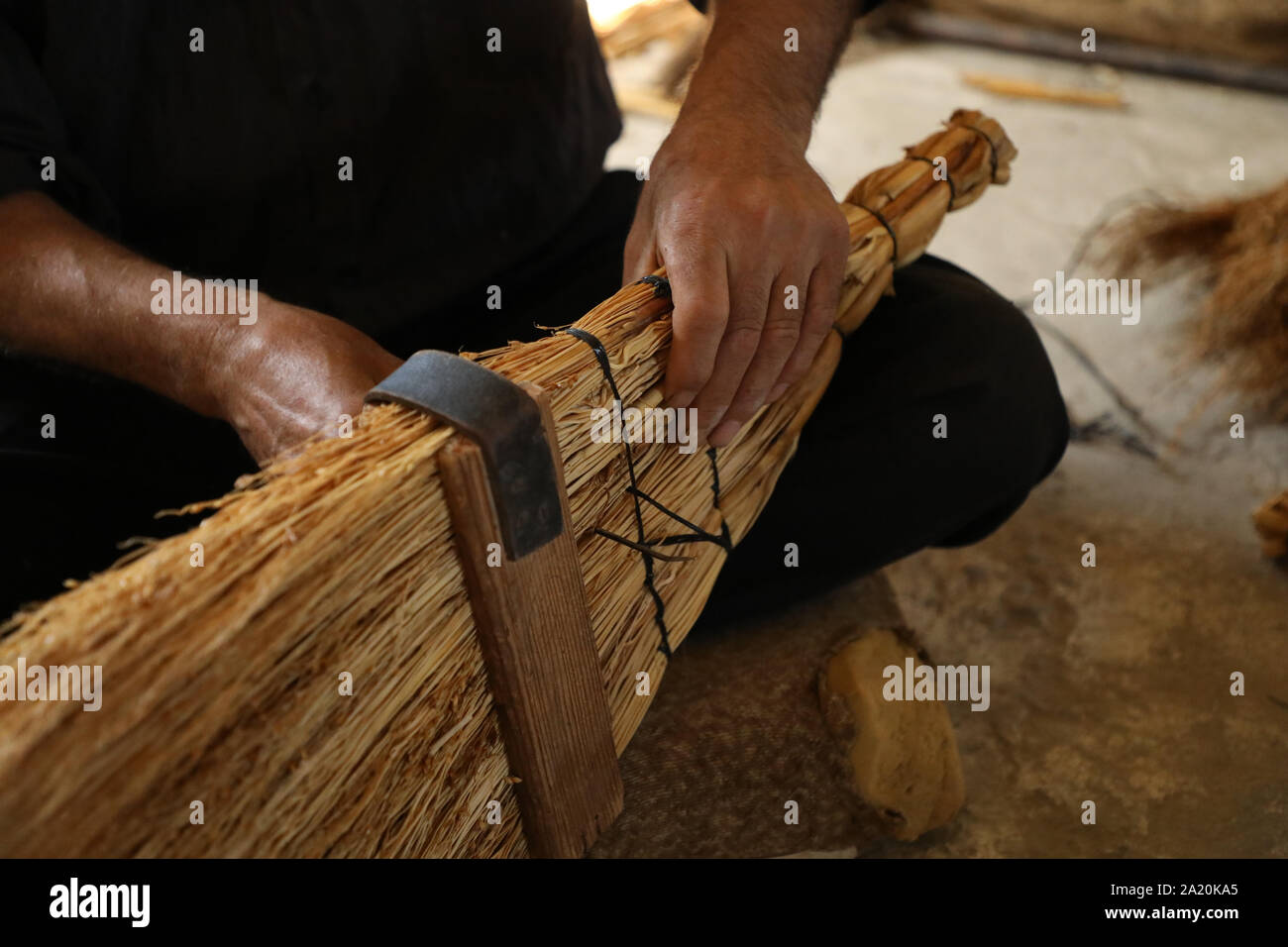 27 settembre 2019: West Bank, Palestina. Il 27 settembre 2019. Sobhi Jaradat, 57, è stata realizzare paglia scope per quasi quindici anni nella West Bank village di Zububa, nel governatorato di Jenin. Per produrre le scope, Jaradat utilizza un tipo speciale di mais, che viene coltivata dagli agricoltori locali dai primi di aprile e richiede cura fino alla fine di luglio. Fusti di mais vengono raccolte, ripuliti dai semi e poi adottate per l'artigiano La creazione di scope. In Palestina, l'arte di ginestra rendendo con paglia tramandata da generazioni e conservati da alcuni esperti artigiani come Sobhi (credito Imag Foto Stock