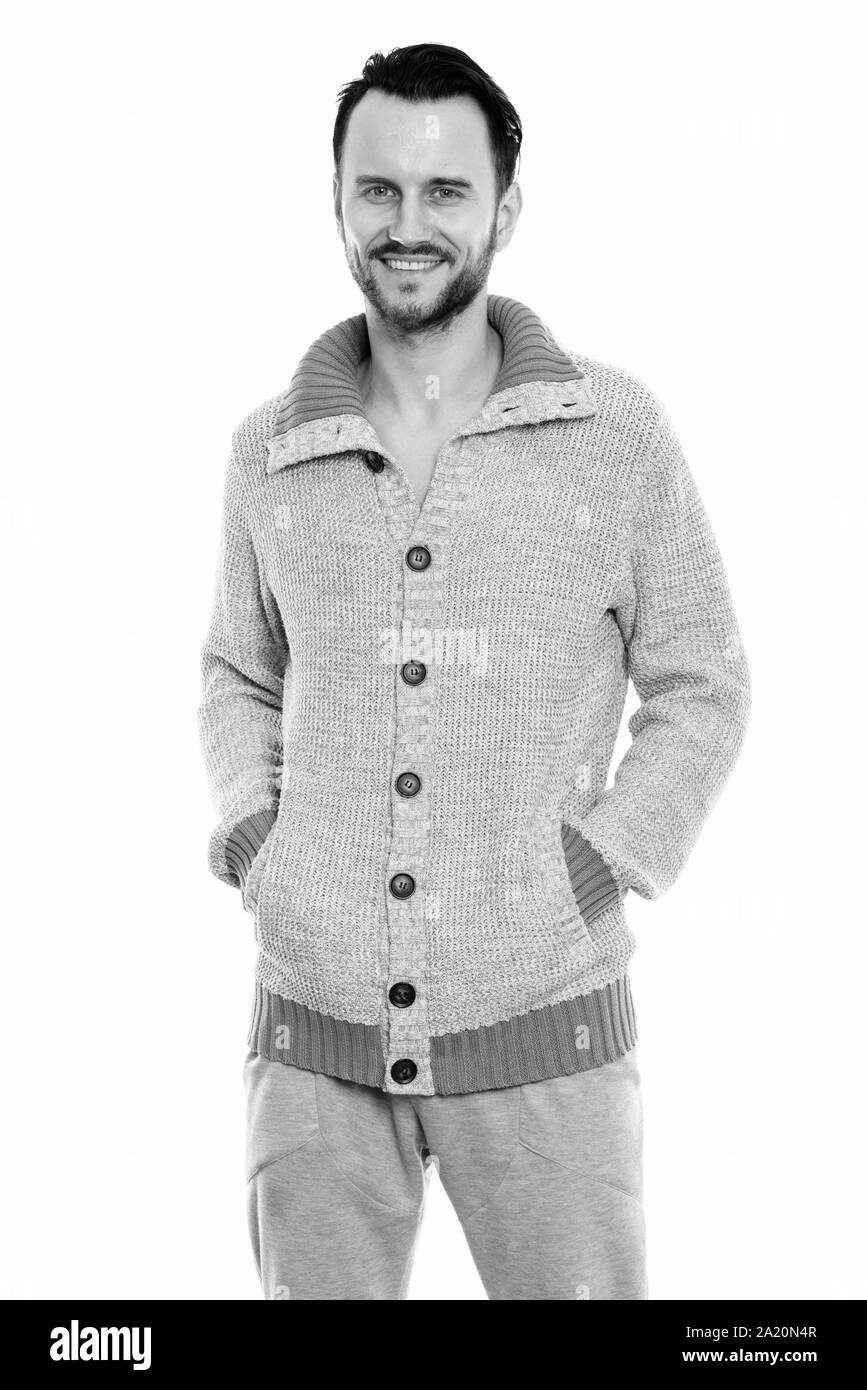 Studio shot di felice giovane uomo sorridente mentre in piedi con le mani sulle tasche Foto Stock