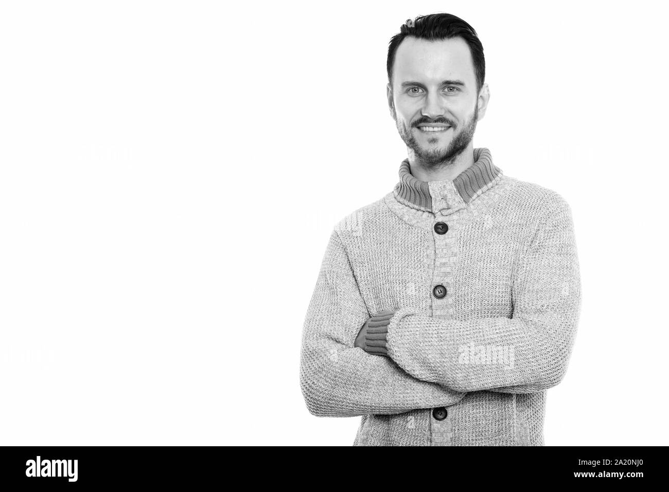 Studio shot di felice giovane uomo sorridente con le braccia incrociate Foto Stock