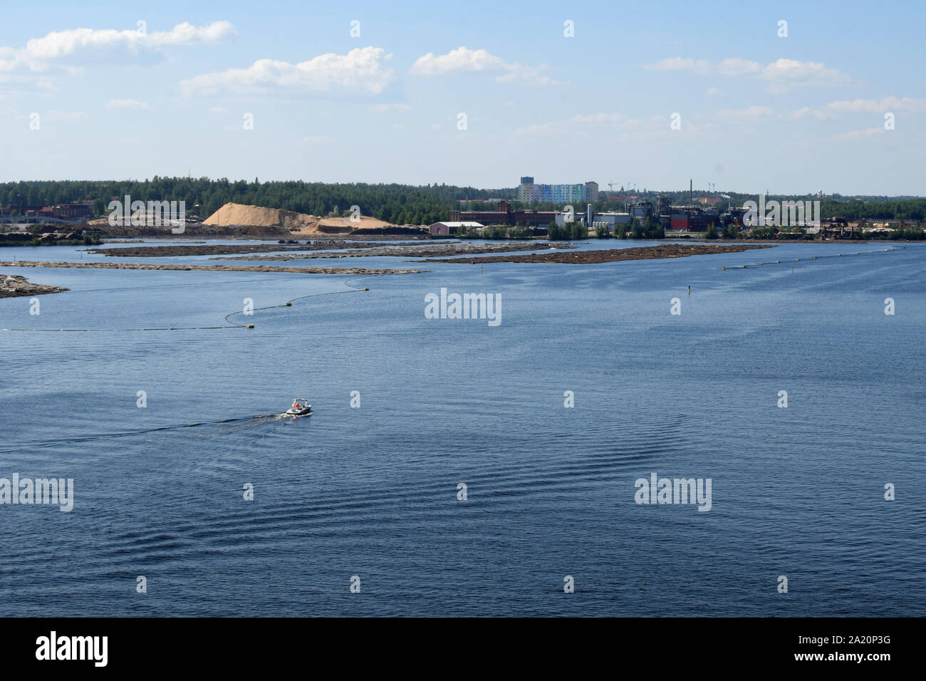 Barca sul Lago Saimaa, Finlandia. Tronchi galleggianti sullo sfondo. Foto Stock