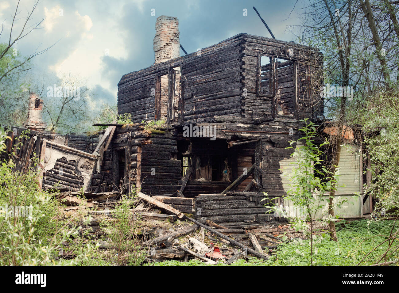 Bruciò legno casa dopo il fuoco, rovinato edificio con tubo da stufa. Foto Stock