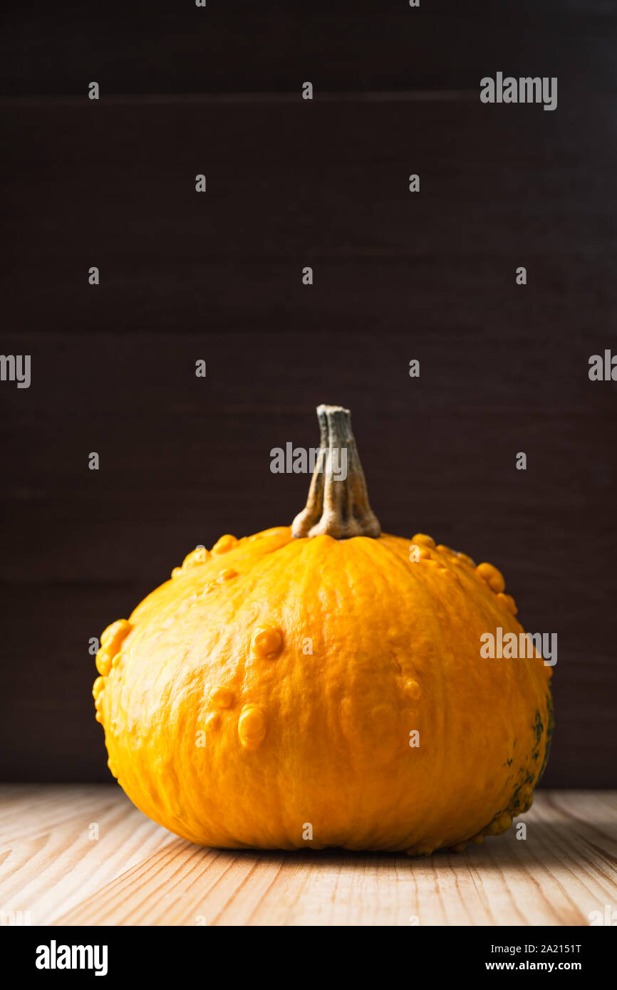 Arancione Zucca di Halloween su una tavola di legno dello sfondo. Orientamento verticale. Spazio copia il triidrato di alluminio superiore. Foto Stock