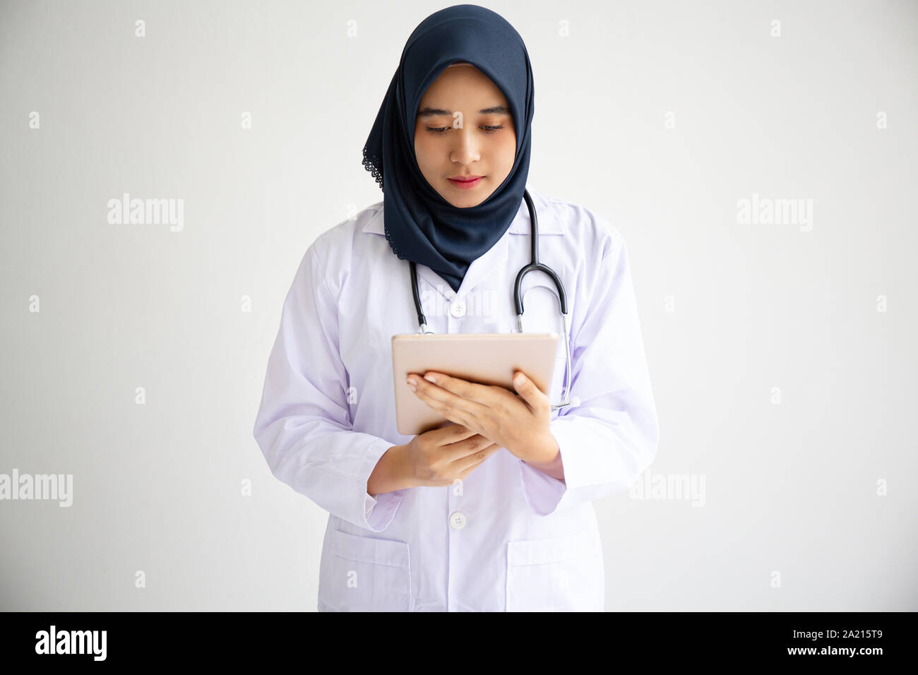 Giovani Musulmani arabi intern medico donne sorriso sulle labbra per isolare lo sfondo bianco concetto per l'Islam persone che lavorano in ospedale medico health care, infermiera moderno Foto Stock