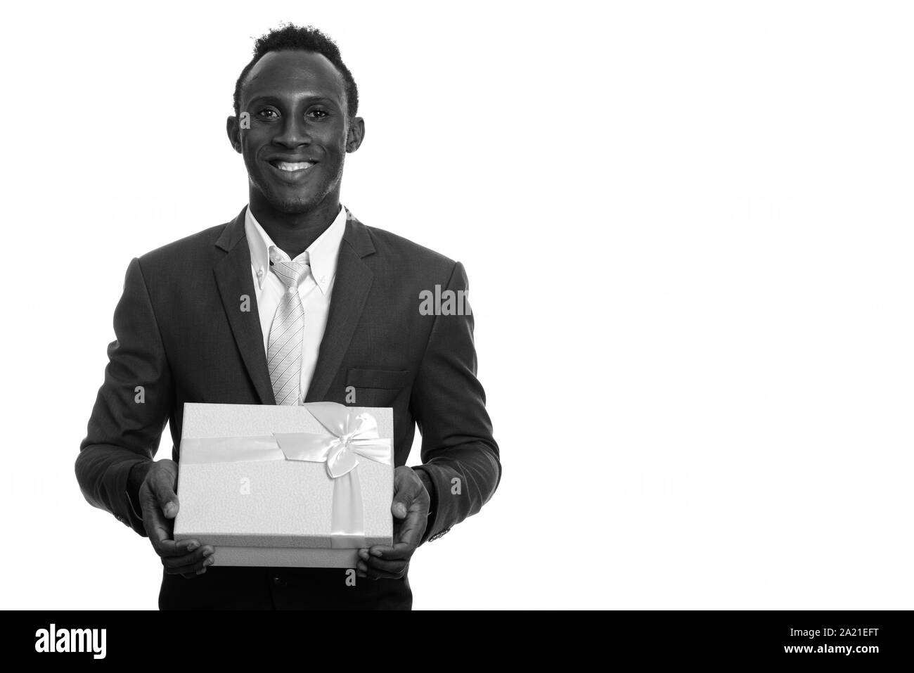 Giovani felici Africano nero imprenditore sorridente tenendo confezione regalo Foto Stock