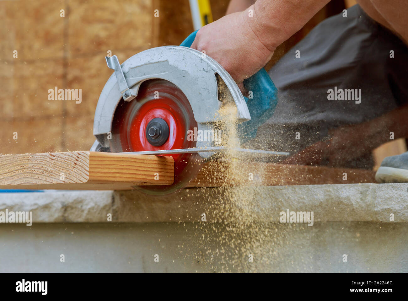 Nuovo home progetto constructiion imprenditore edile lavoratore utilizzando tenuto in mano unità worm sega circolare per il taglio di pannelli Foto Stock