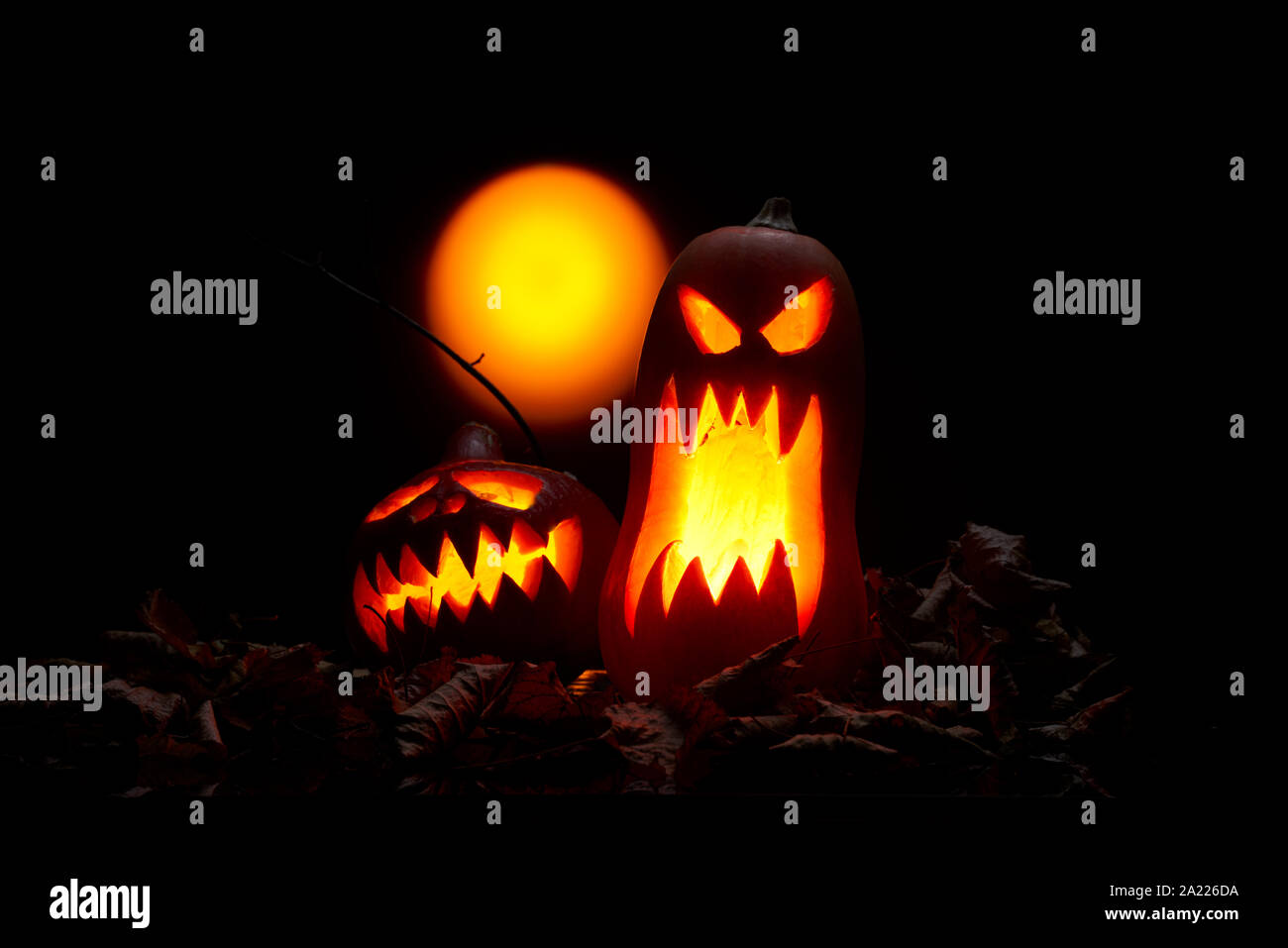 Foto di zucche di Halloween con bocche di masterizzazione, luna vuota su sfondo nero in studio Foto Stock