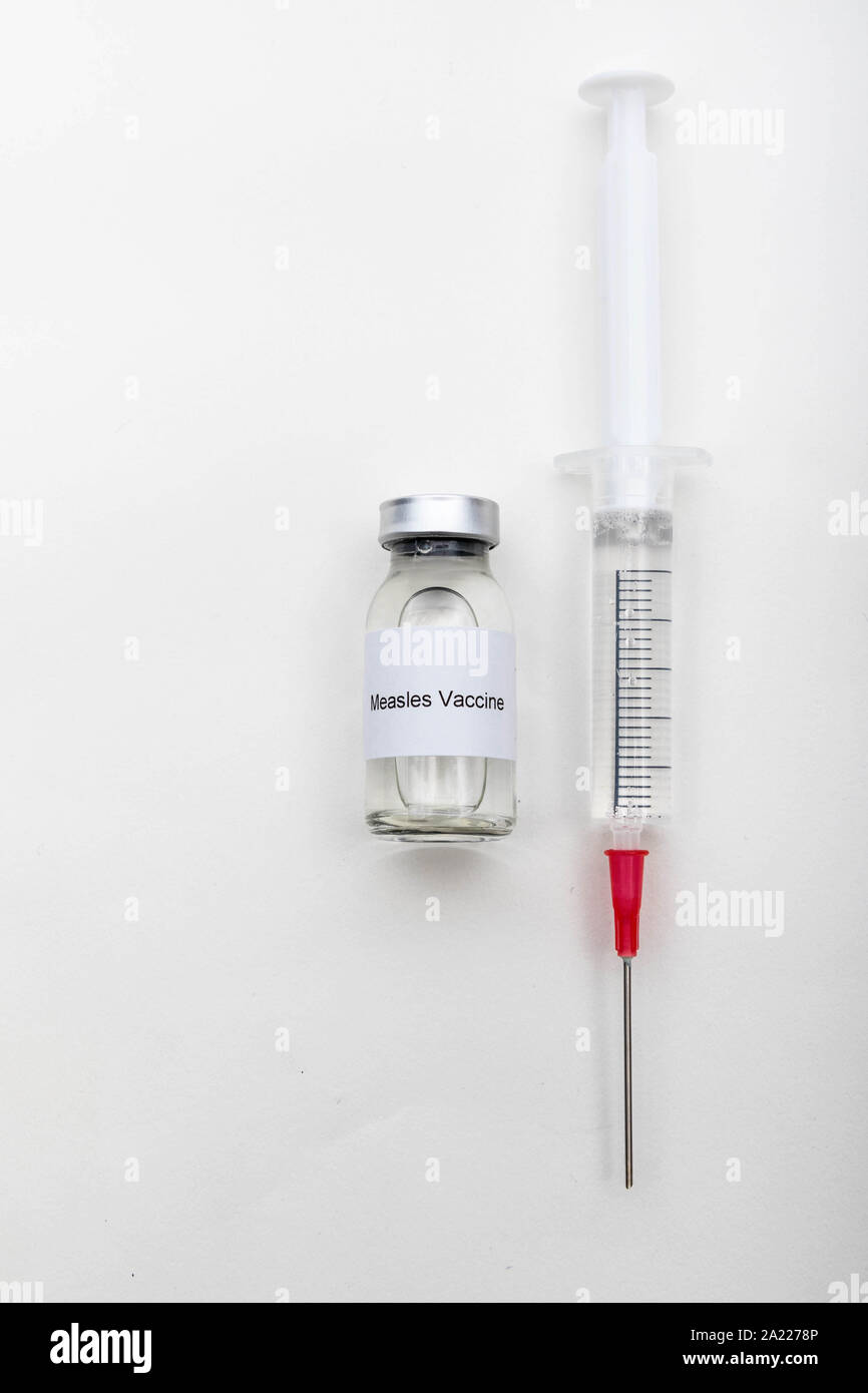 Concetto medico medico che mostra una fiala medica leggendo il vaccino del morbillo e una siringa Foto Stock