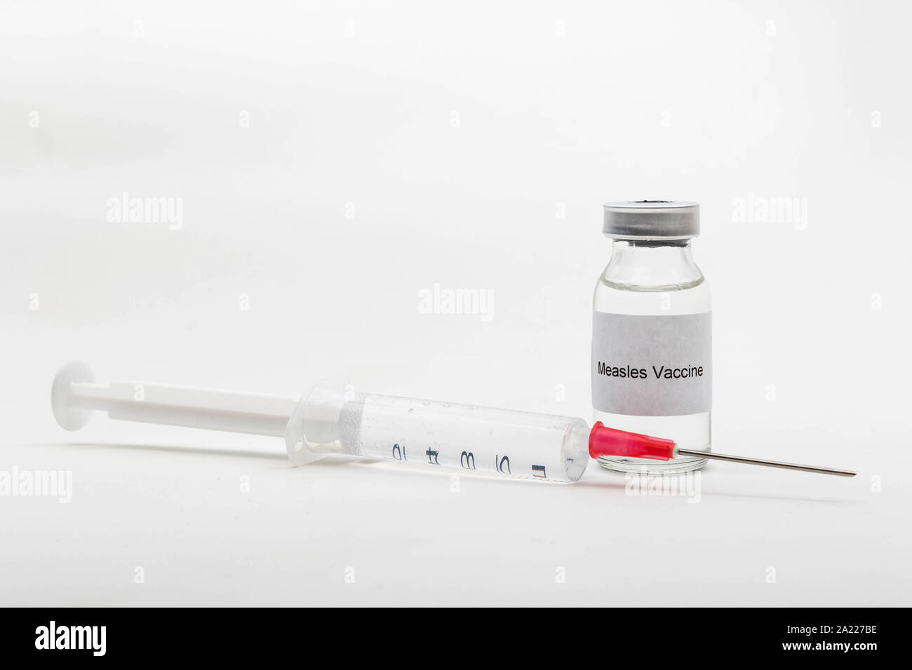 Concetto medico medico che mostra una fiala medica leggendo il vaccino del morbillo e una siringa Foto Stock