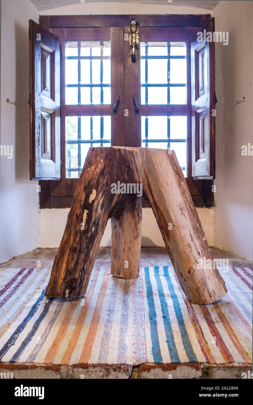 Tre gambe moncone sgabello realizzato con il tronco e i rami principali. Rustico design home Foto Stock