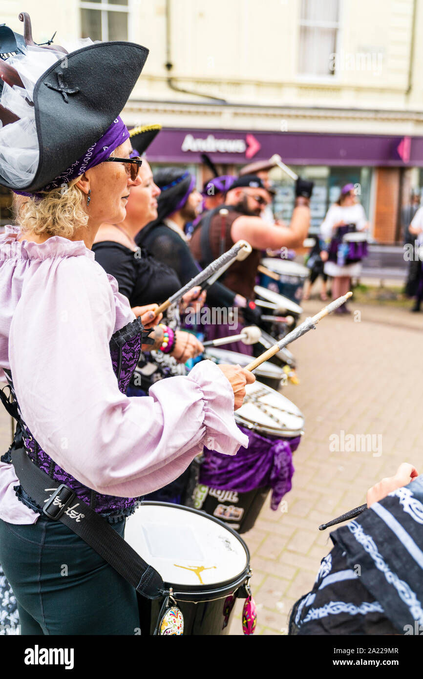 Giorno pirata in Hastings, Regno Unito. Vista ravvicinata lungo la fila di Stix batteristi drumming, in piedi in una linea nel centro della città. Indossando il costume dei pirati. Ore diurne. Foto Stock