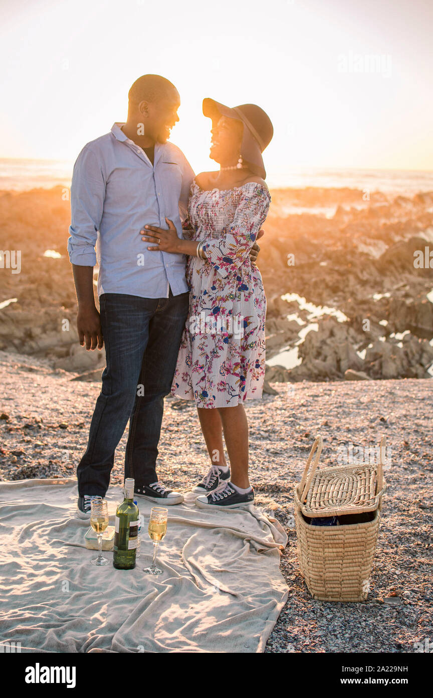 Coppia giovane avente picnic nella spiaggia Foto Stock