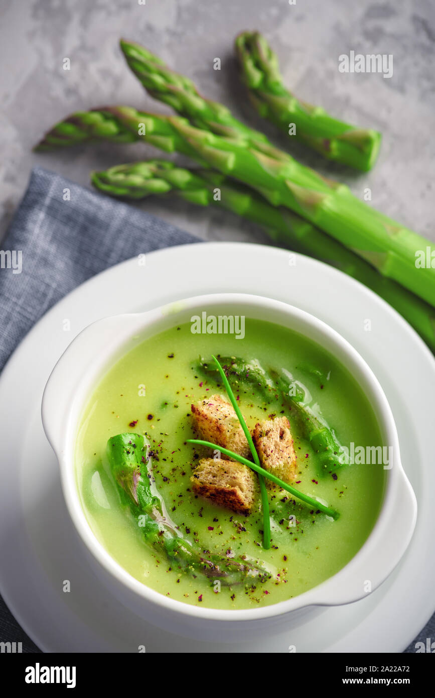 Gli asparagi verdi zuppa in ciotola bianco closeup. Fotografia di cibo Foto Stock