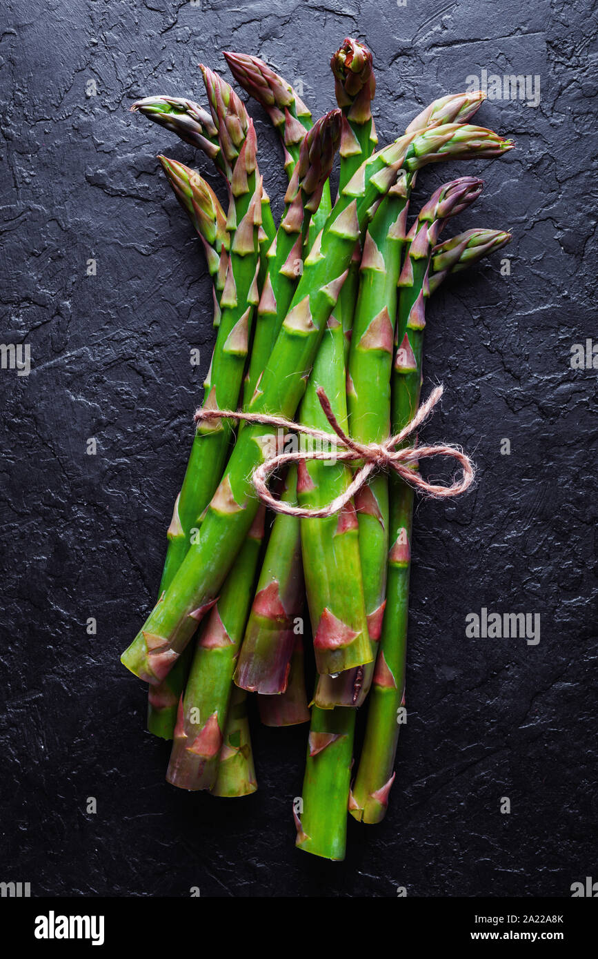 Gli asparagi verdi germogliano sulla lavagna nera top view flat lay Foto Stock