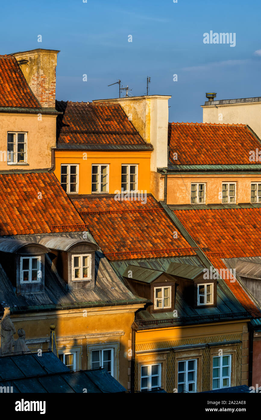 Tetti di tegole rosse di case colorate al tramonto nel centro storico della città di Varsavia in Polonia. Foto Stock