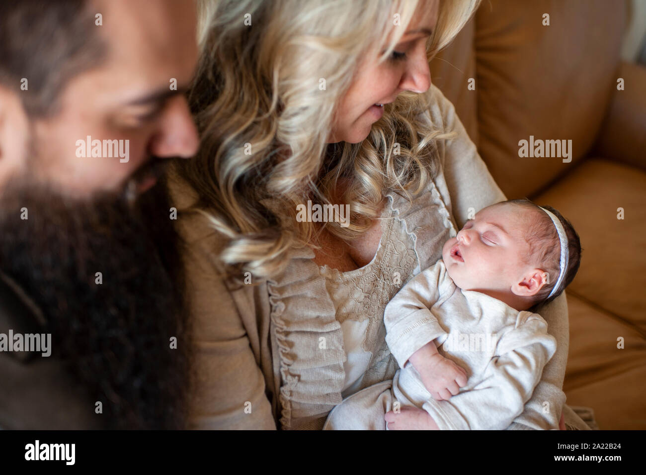 Il padre e la madre guardando il loro neonato ragazza sul lettino a casa Foto Stock