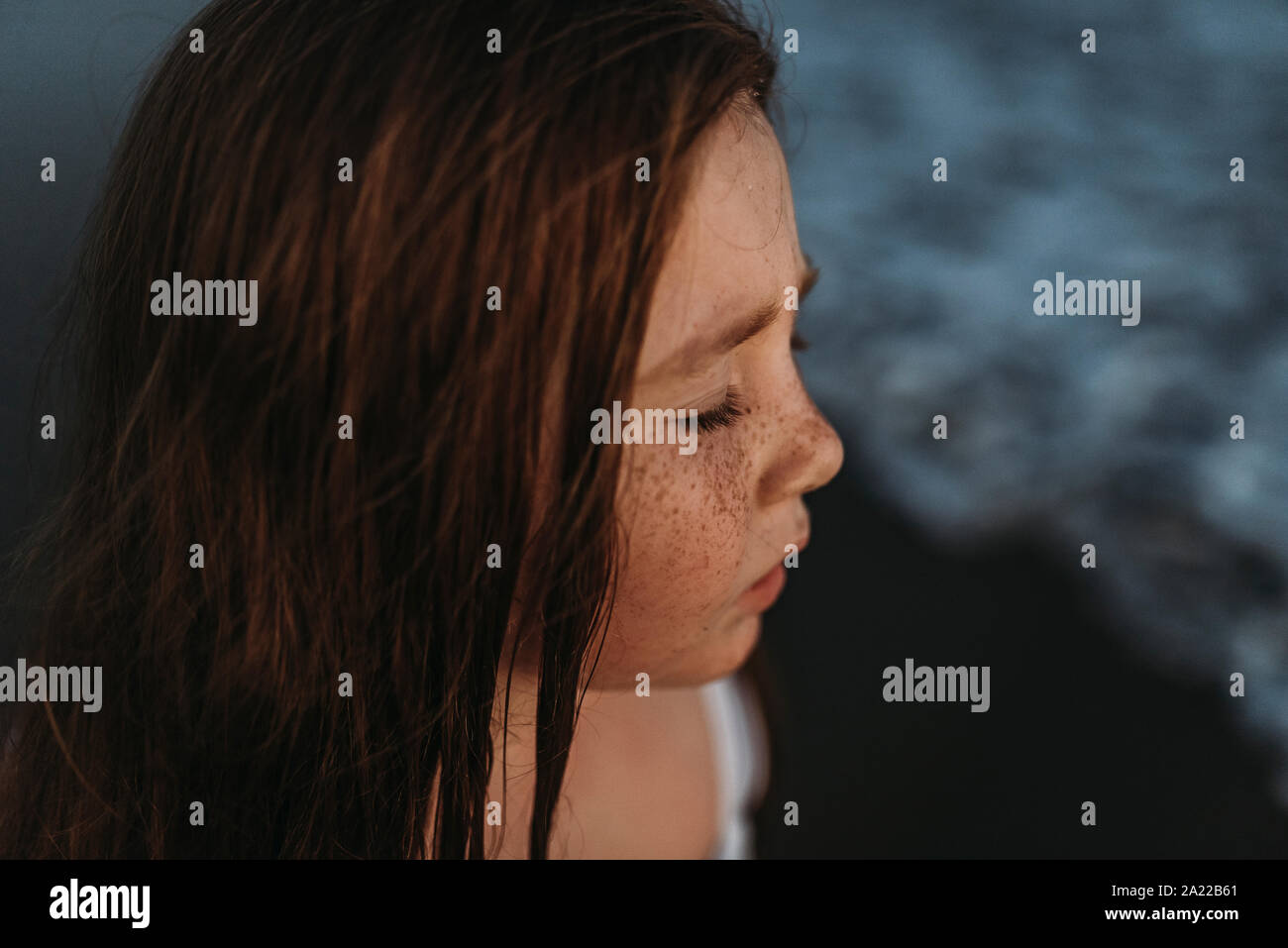 Ritratto di carino con testa rossa ragazza con lentiggini chiudendo gli occhi in ocean Foto Stock