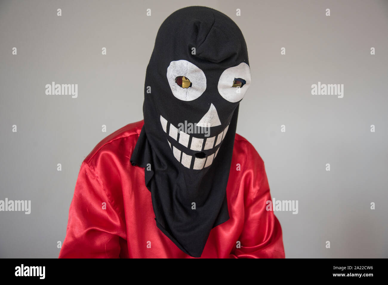 Ragazzo seduto con maschera di Halloween e costume rosso Foto Stock
