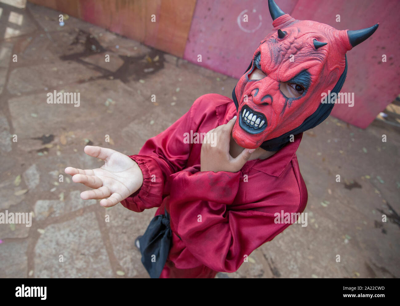 Dolcetto o scherzetto - ragazzo con Halloween maschera di demone di accattonaggio Foto Stock
