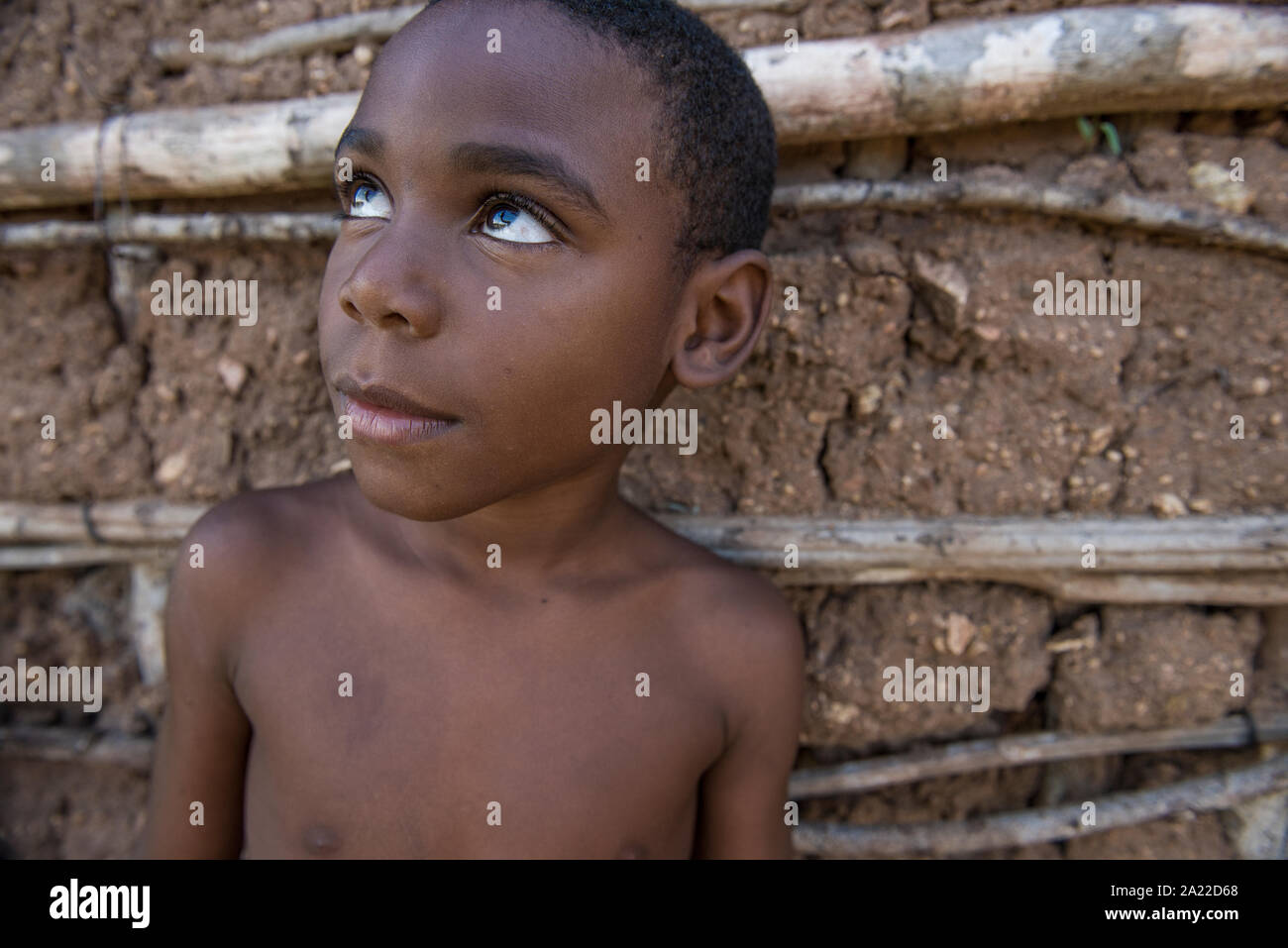 Ragazzo afro-brasiliana cercando su una argilla casa sullo sfondo Foto Stock