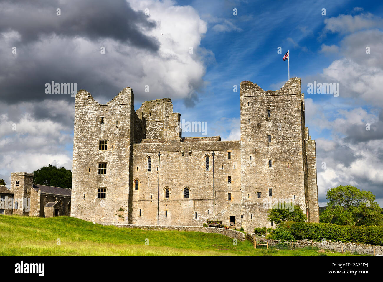 Lato ovest del XIV secolo il castello di Bolton in sun con bandiera britannica Wensleydale Yorkshire Inghilterra Foto Stock