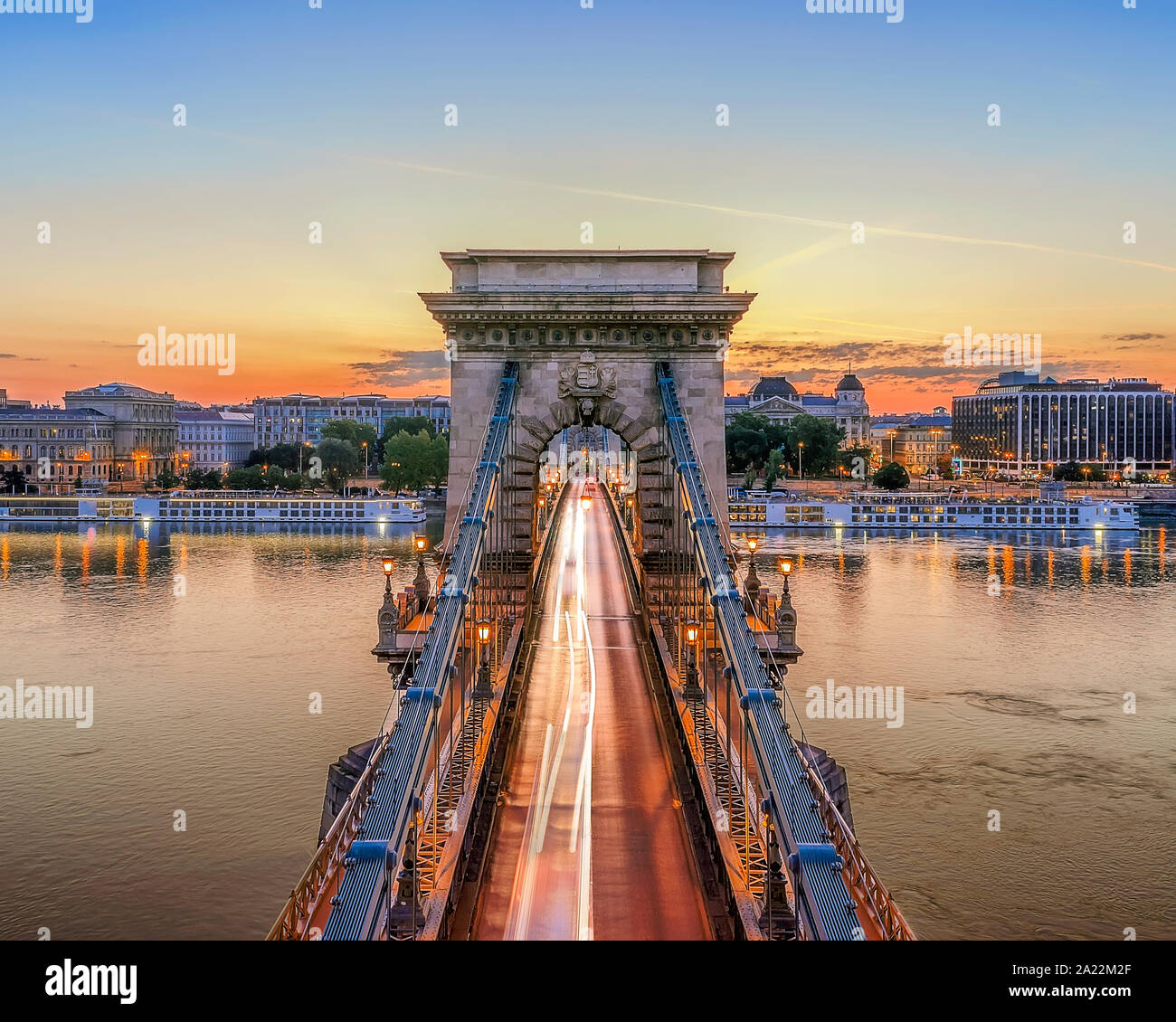 Il Ponte delle catene a Budapest, Ungheria. Fiume Danubio con barche. Traffico di sera con la luce dei sentieri. Paesaggio urbano dell'antenna. Foto Stock