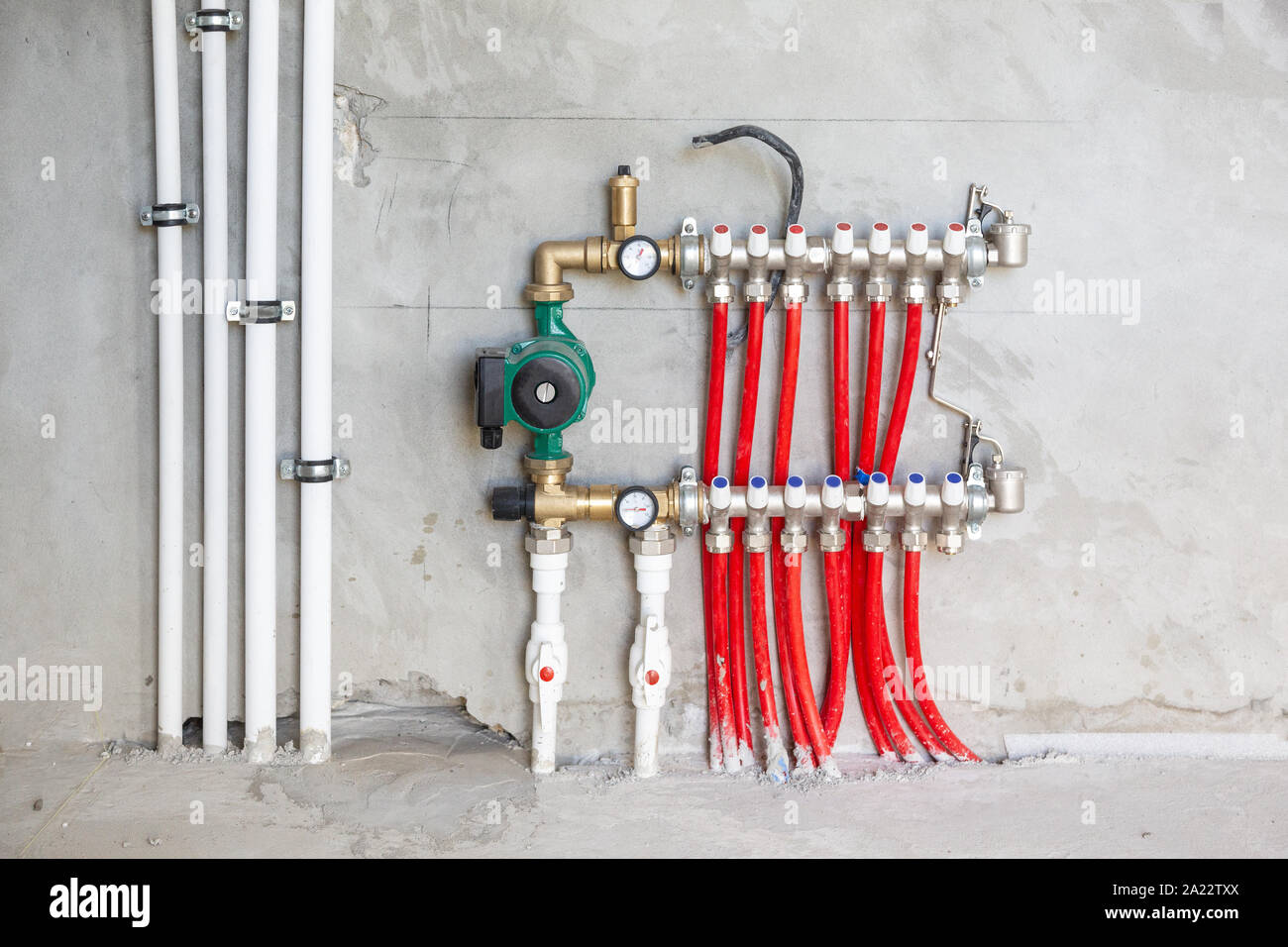 Pavimento radiante di Installazione sistema di riscaldamento. L'uomo installare sotto il pavimento per il riscaldamento di acqua di costruzione del pavimento. Riscaldamento a pavimento l'installazione. Foto Stock