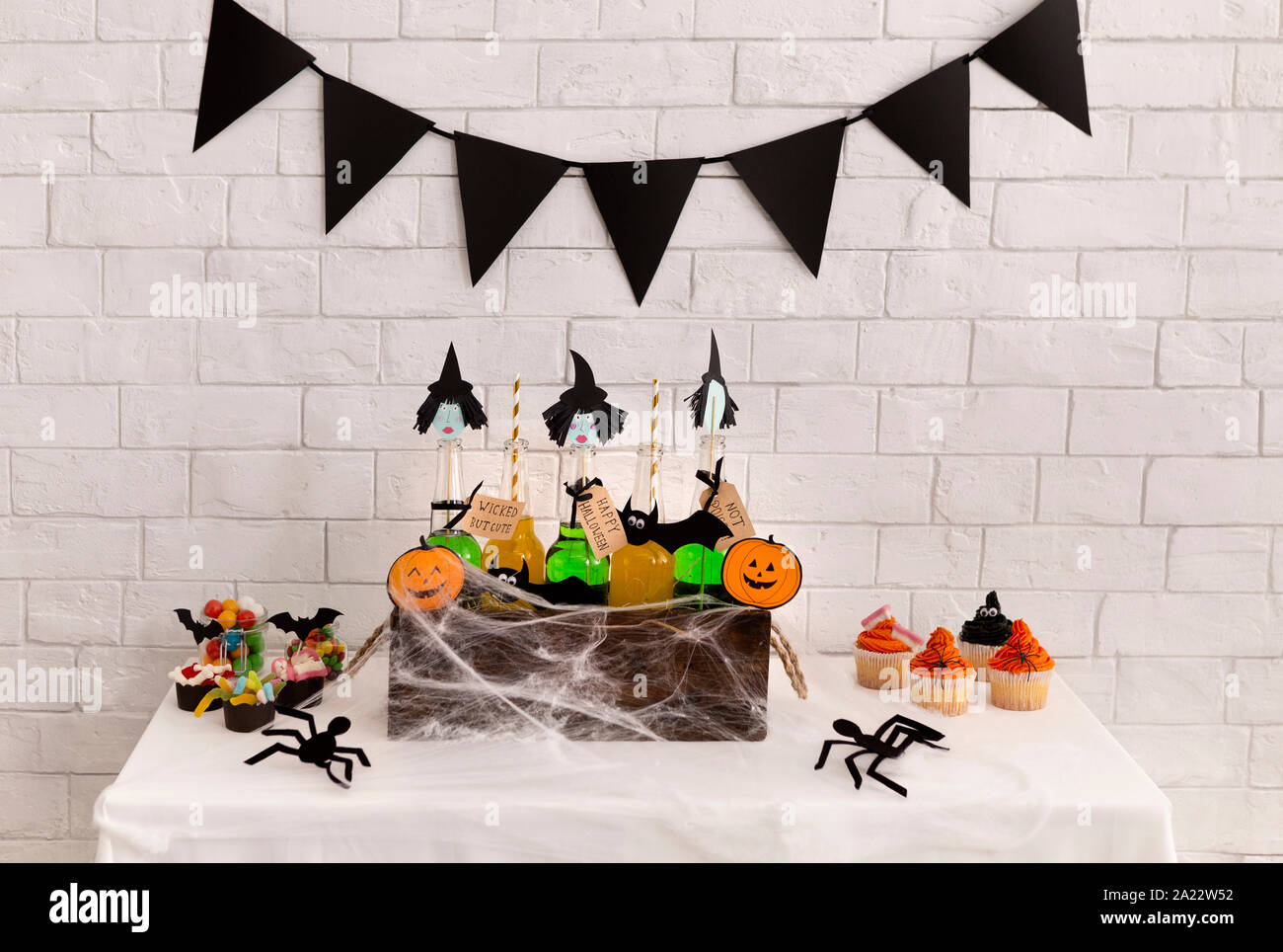 Scary Halloween concetto. Le streghe verdi bevande in bottiglie di vetro all'interno della scatola ricoperta con spider web sullo sfondo Foto Stock