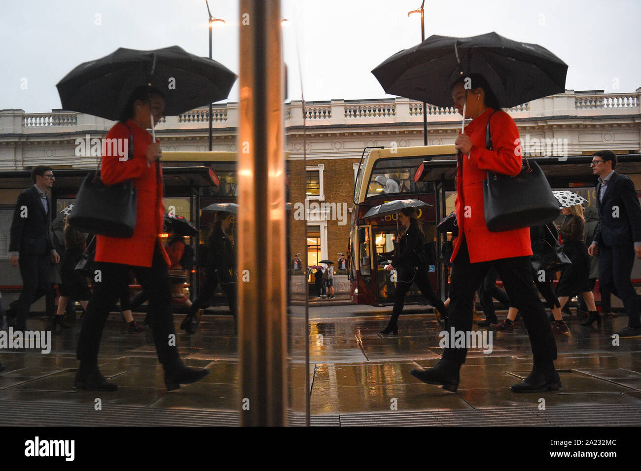 Pendolari cross London Bridge, come parti della Gran Bretagna tutore per altri due giorni di acquazzoni pesanti, precedendo di nevicate e gli avanzi di un uragano più tardi questa settimana. Foto Stock