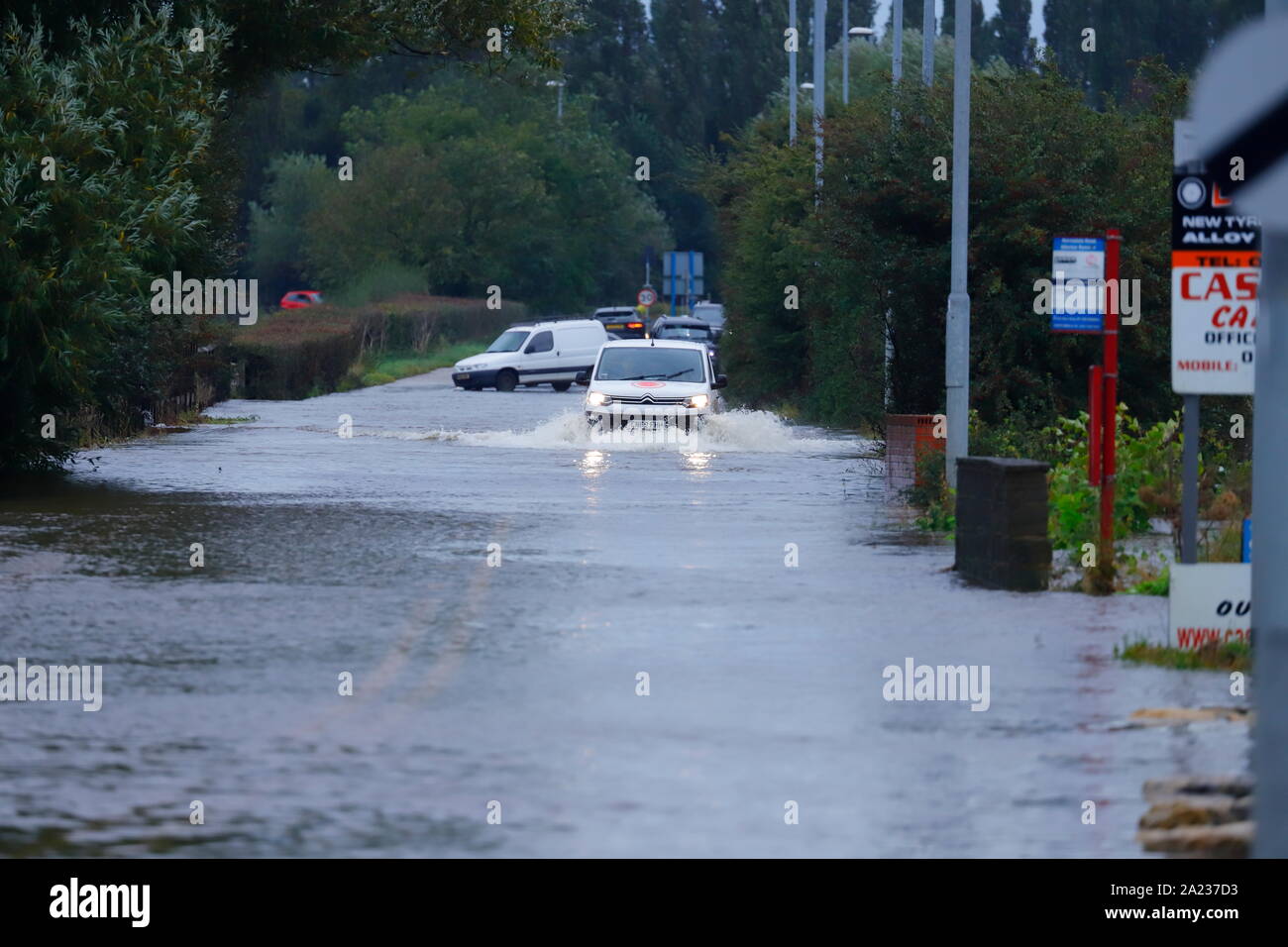 I veicoli guida lungo una strada allagata tra Castleford & Allerton Bywater Foto Stock