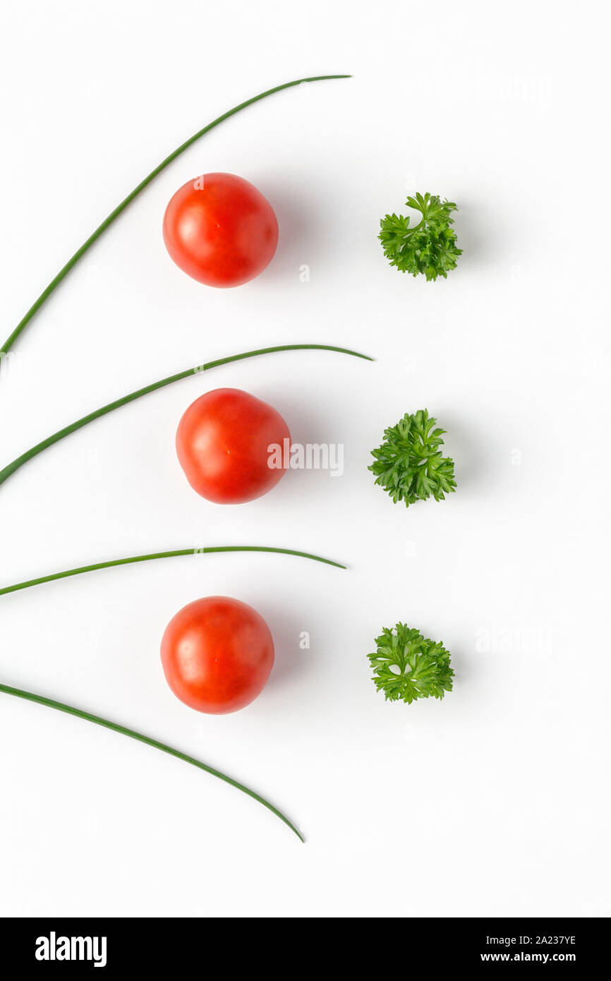 Il pomodoro fresco, erba cipollina e prezzemolo in una linea Foto Stock
