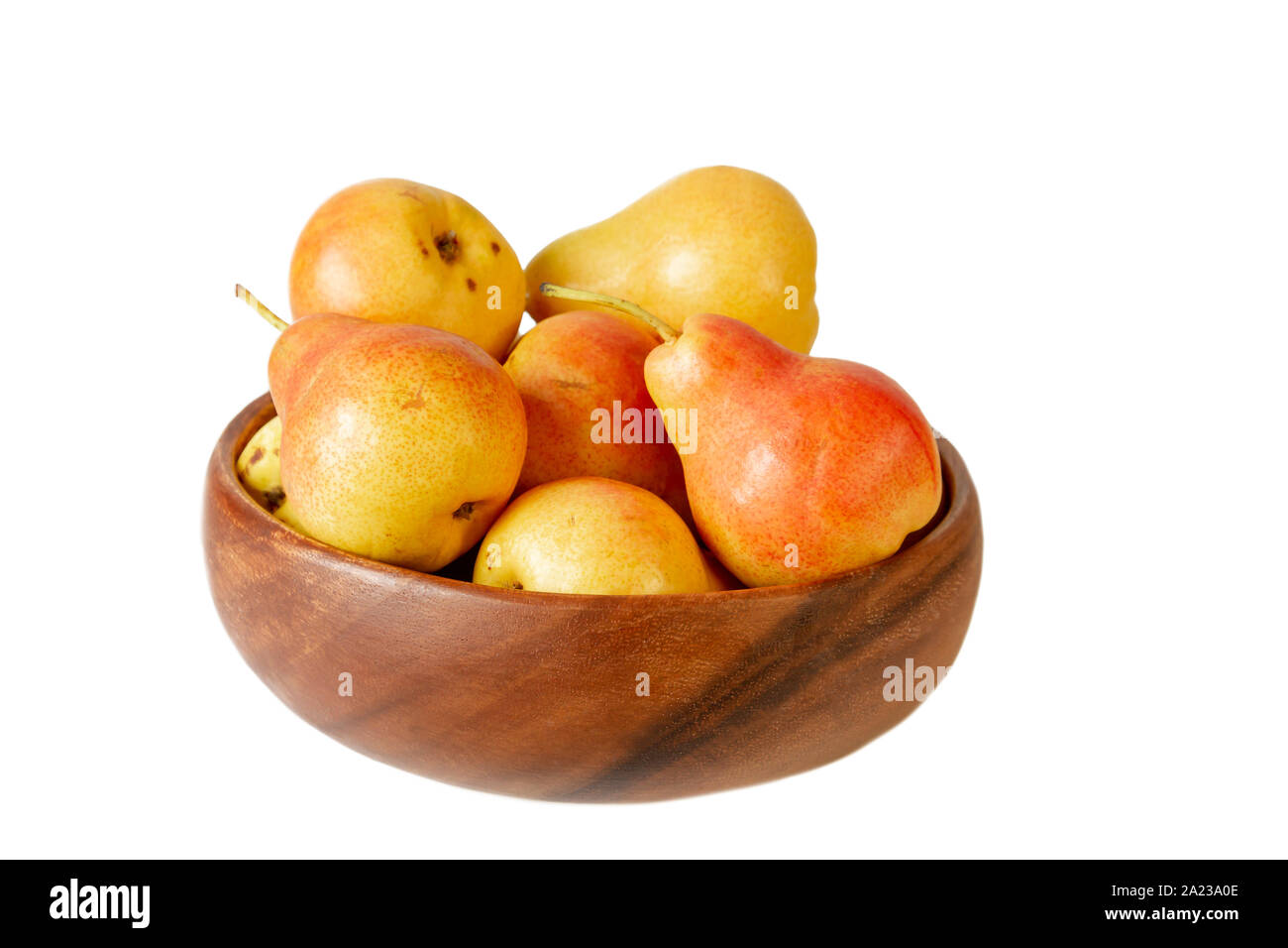 Pera in ciotola di legno su bianco. Pera organica frutta isolato su sfondo bianco. Foto Stock