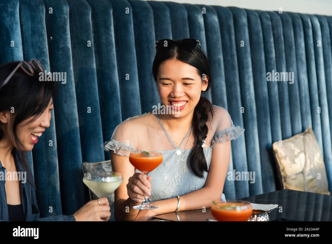 Asian Girls tostare con un cocktail presso il bar Foto Stock