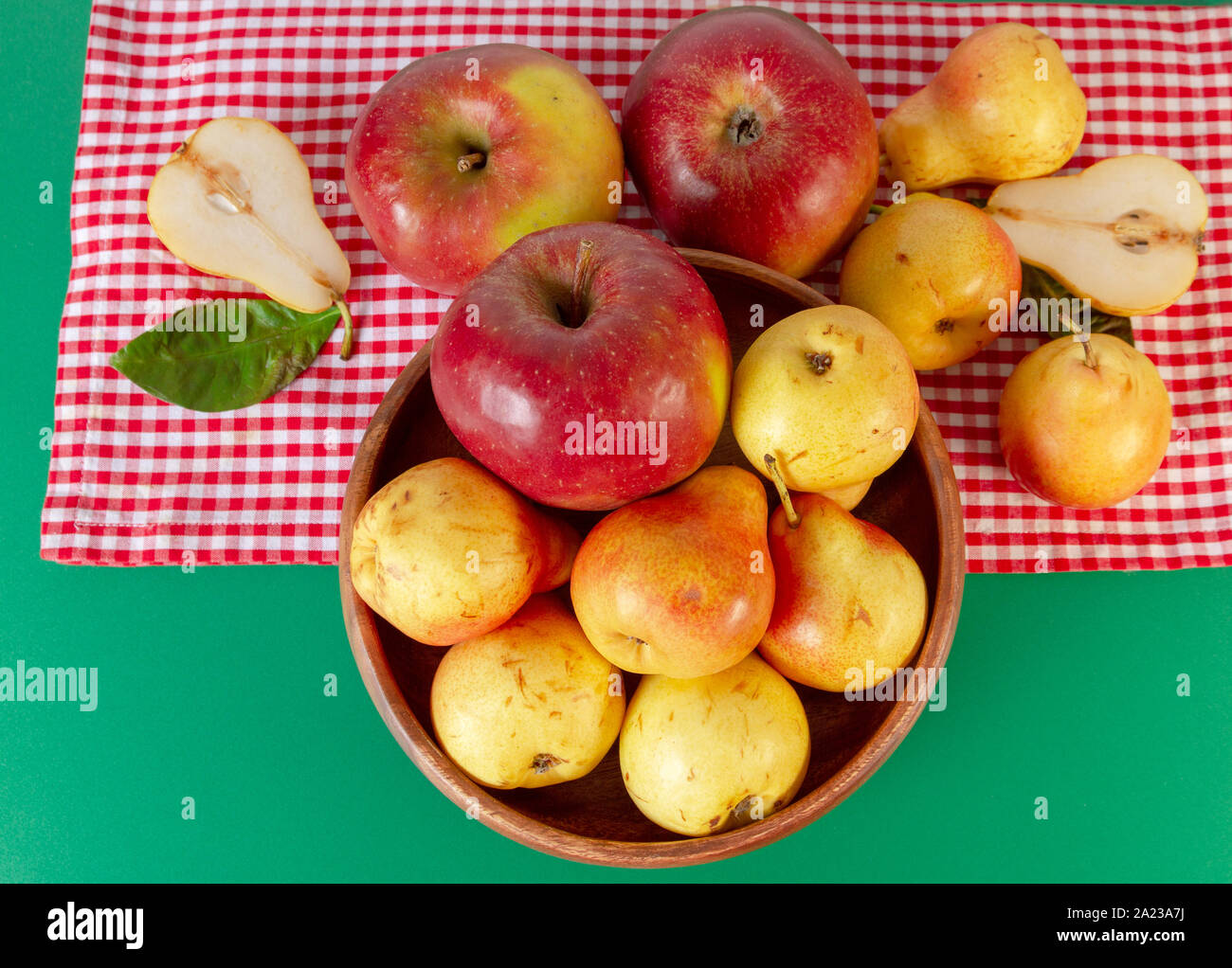 Autunno ancora in vita. Pera e mela sul tavolo verde con rosso tovaglia a scacchi. Dal design rustico. Foto Stock