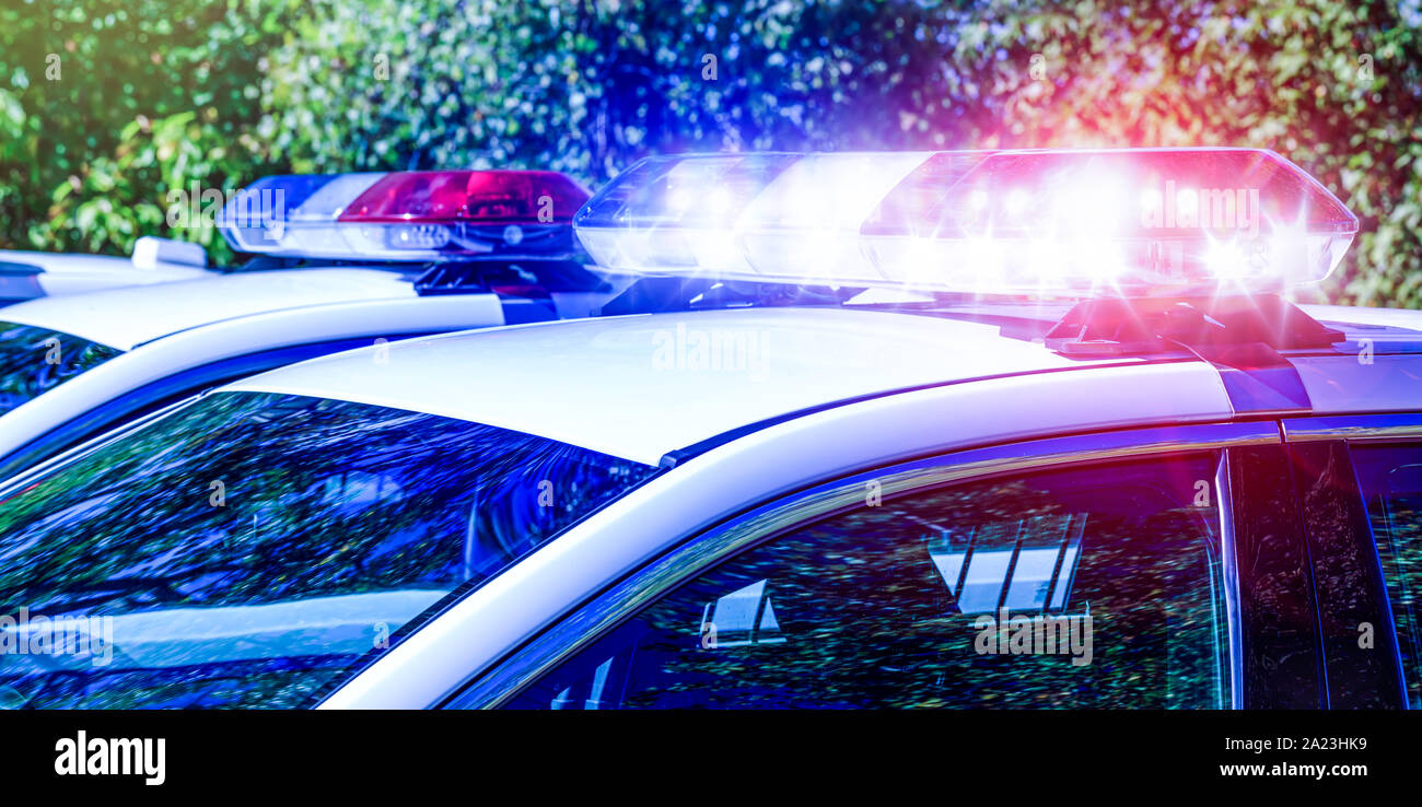 Luci di polizia sulla vettura durante la sorveglianza del traffico sulla strada della città. La luce del flash sul veicolo dei servizi di emergenza. Il rosso e il blu lampeggia sul c Foto Stock