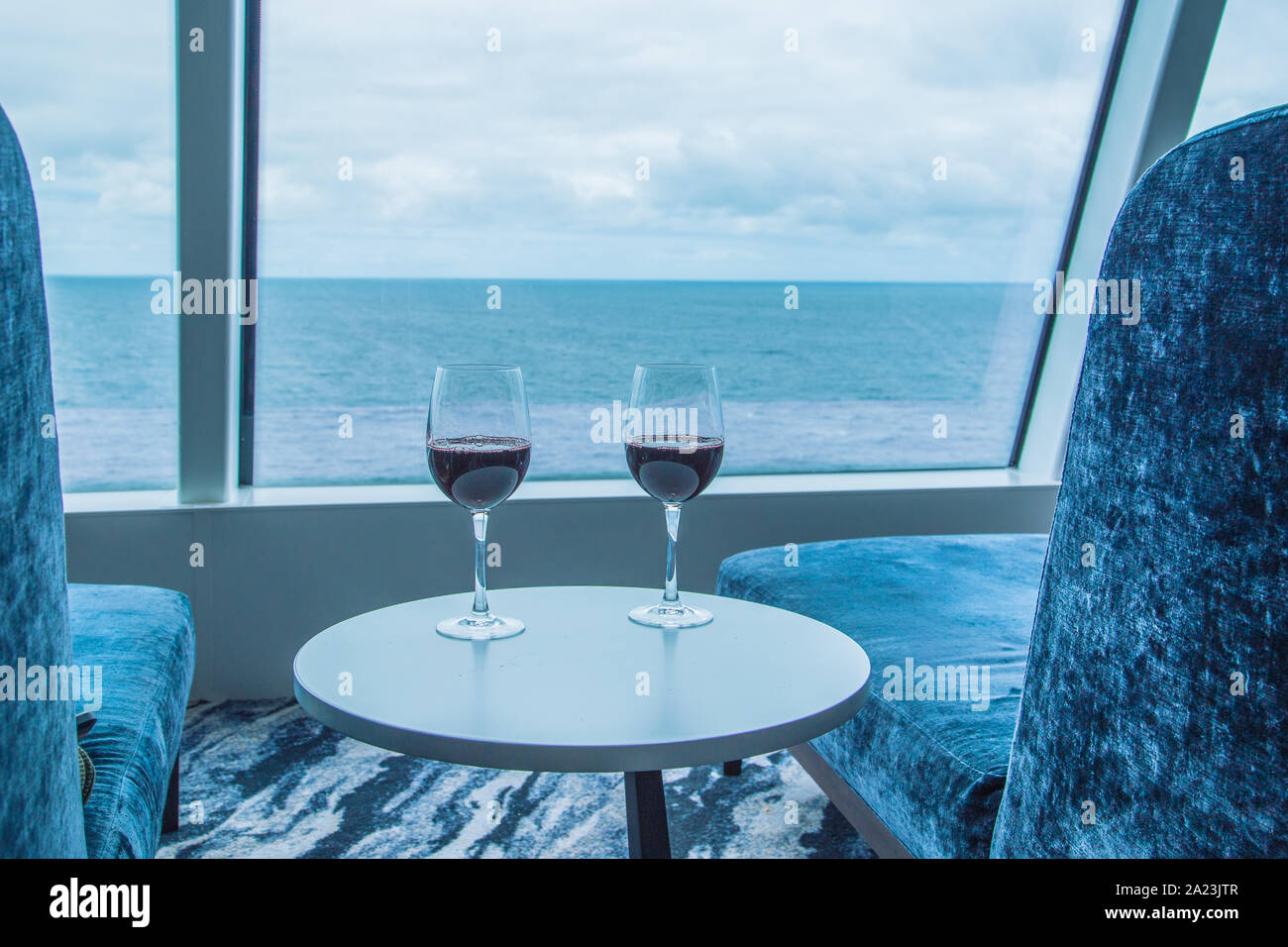 Due bicchieri di vino rosso con vista dell'oceano su NCL Bliss Foto Stock
