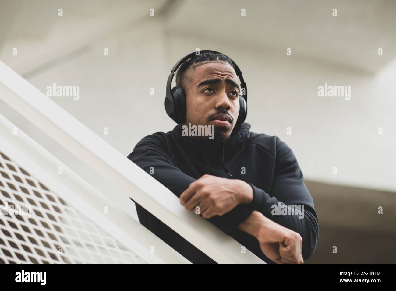Giovane americano africano uomo in piedi fuori l'ascolto di musica. Foto Stock