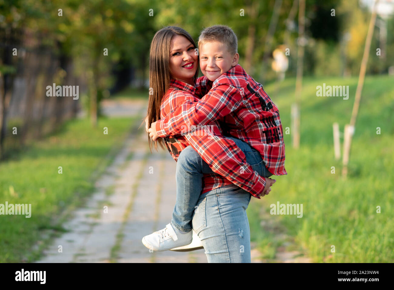 La mamma con un sorriso trattiene il suo figlio nelle sue braccia. Foto Stock