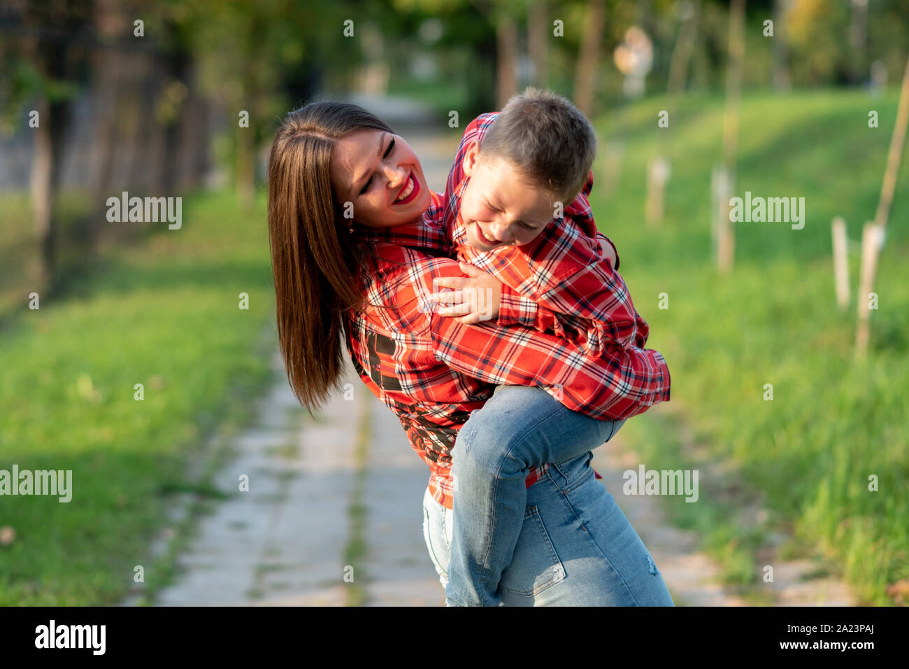 Mom, giocando, ha preso il suo figlio nelle sue braccia, entrambi ridere. Foto Stock