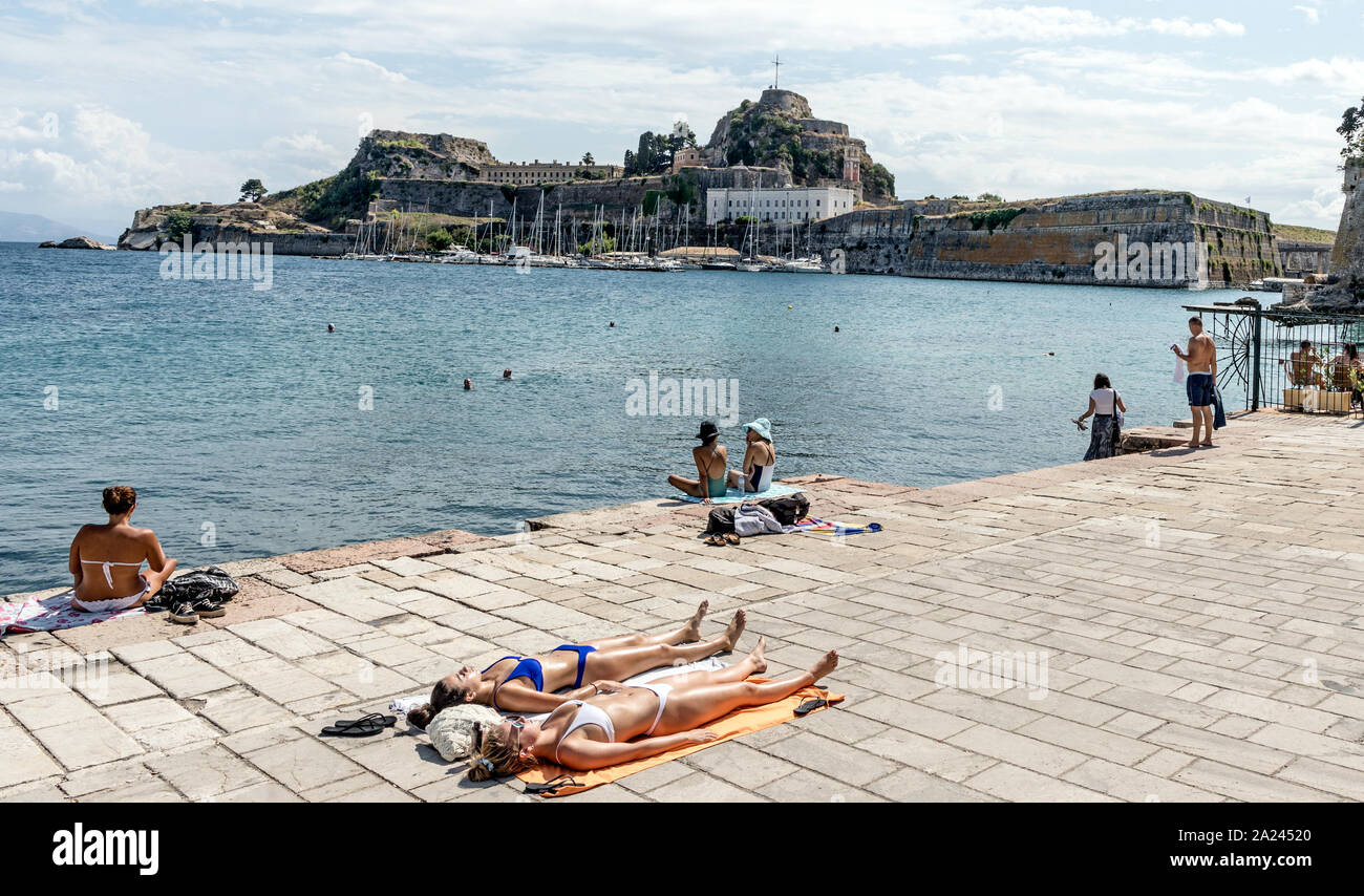 Le donne a prendere il sole di fronte alla fortezza vecchia citta di Corfu isole Greche - Grecia Foto Stock