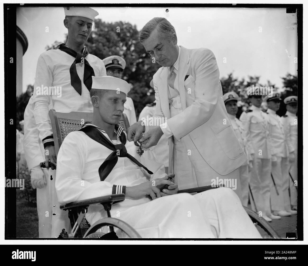 Panay hero riceve traversa di marina. Washington, 1 luglio. Fireman prima classe John L. Hodge ha, che è ricoverato in ospedale navale qui oggi è stata decorata con la croce della Marina militare per il coraggio che egli viene visualizzato durante il naufragio dell'U.S. cannoniere Panay dalle bombe giapponesi lo scorso anno. Assistente del segretario della Marina Charles Edison è raffigurato il pinning il premio sul Bluejacket. Essa è stata Hodge ha chi ha portato Jim Marshall, staff writer per Collier's feriti nell' attentato, dalla scena del naufragio nave a Wuhu, Cina, a una distanza di circa 17 miglia, 7/1/38 Foto Stock Panay hero riceve traversa di marina. Washington, 1 luglio. Fireman prima classe John L. Hodge ha, che è ricoverato in ospedale navale qui oggi è stata decorata con la croce della Marina militare per il coraggio che egli viene visualizzato durante il naufragio dell'U.S. cannoniere Panay dalle bombe giapponesi lo scorso anno. Assistente del segretario della Marina Charles Edison è raffigurato il pinning il premio sul Bluejacket. Essa è stata Hodge ha chi ha portato Jim Marshall, staff writer per Collier's feriti nell' attentato, dalla scena del naufragio nave a Wuhu, Cina, a una distanza di circa 17 miglia, 7/1/38 Foto Stock