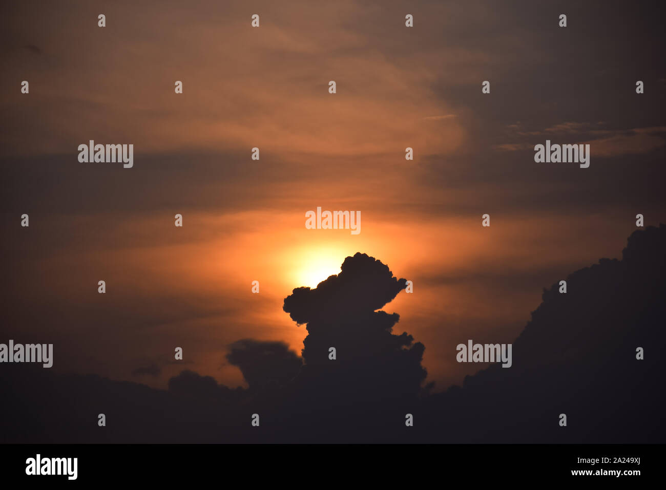 Sun rise e sun impostare lo sfondo giallo, arancio e nero nuvole nel cielo. Foto Stock