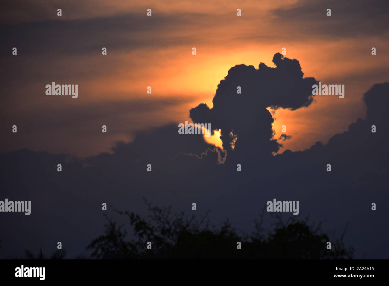 Sun rise e sun impostare lo sfondo giallo, arancio e nero nuvole nel cielo.. Foto Stock