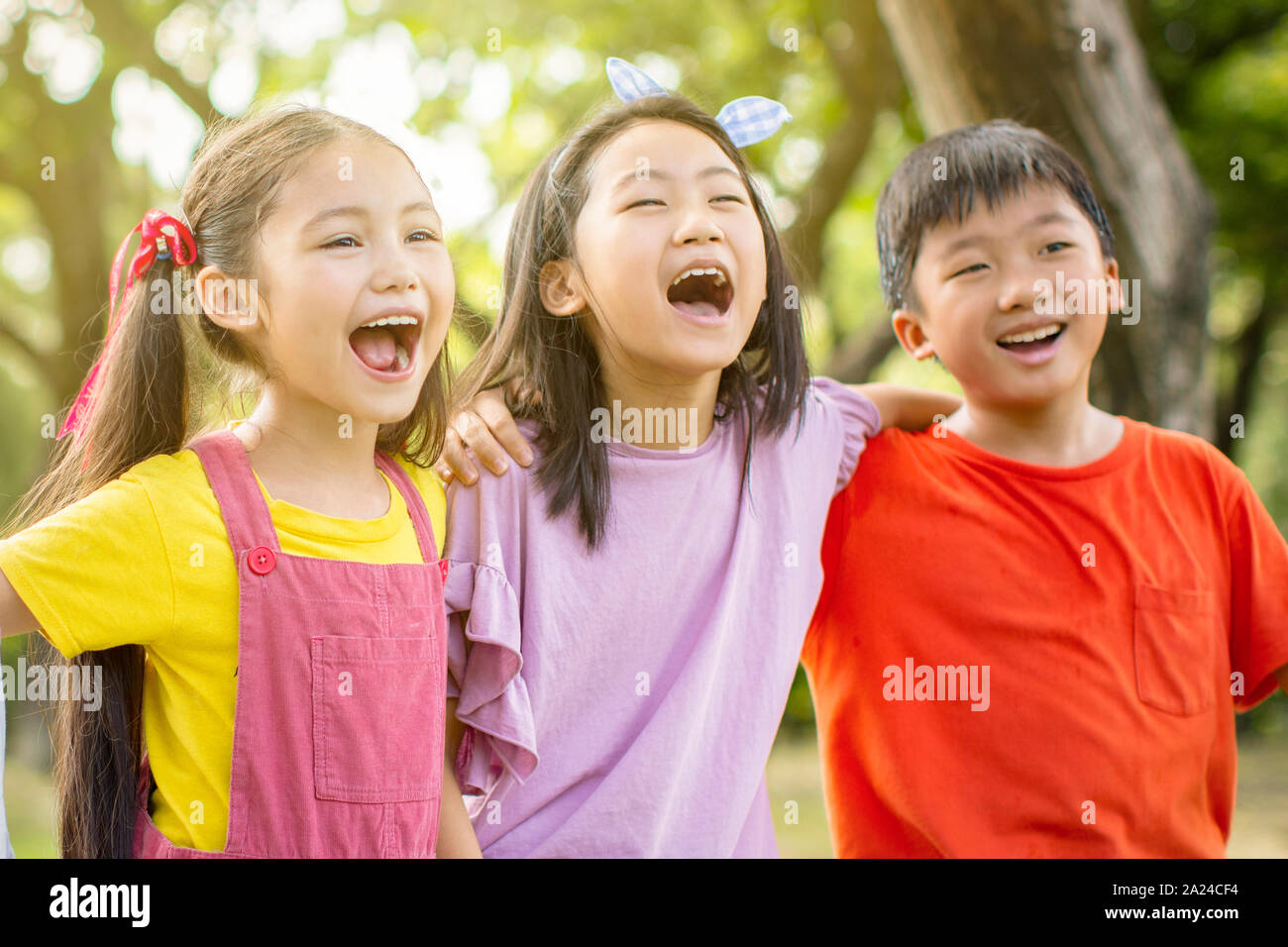 Multi-etnico gruppo di ragazzi delle scuole di ridere e abbracciando Foto Stock