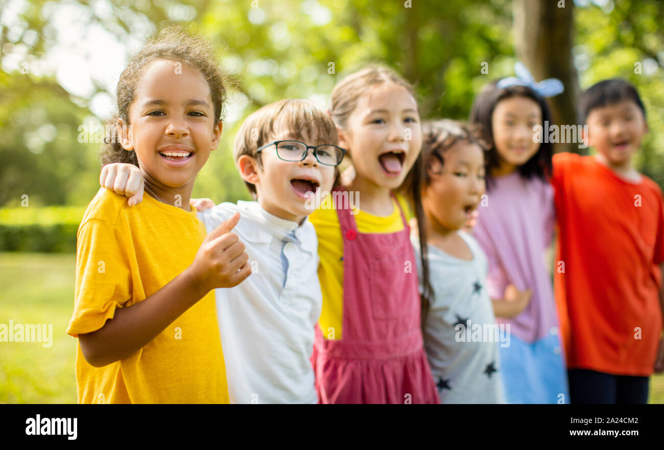Multi-etnico gruppo di bambini della scuola di ridere e abbracciando Foto Stock
