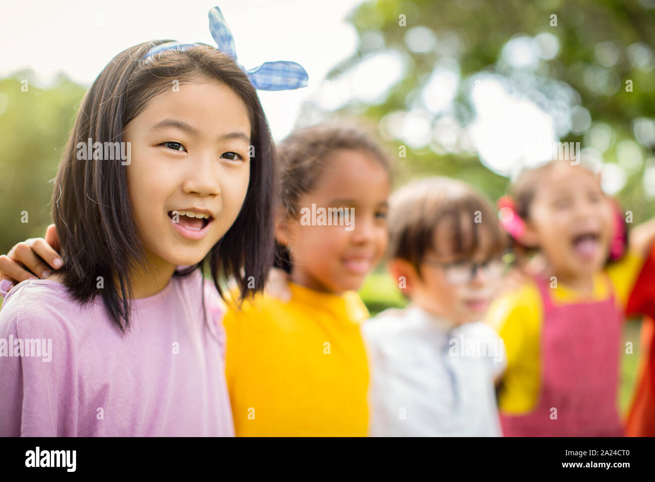 Multi-etnico gruppo di bambini della scuola di ridere e abbracciando Foto Stock