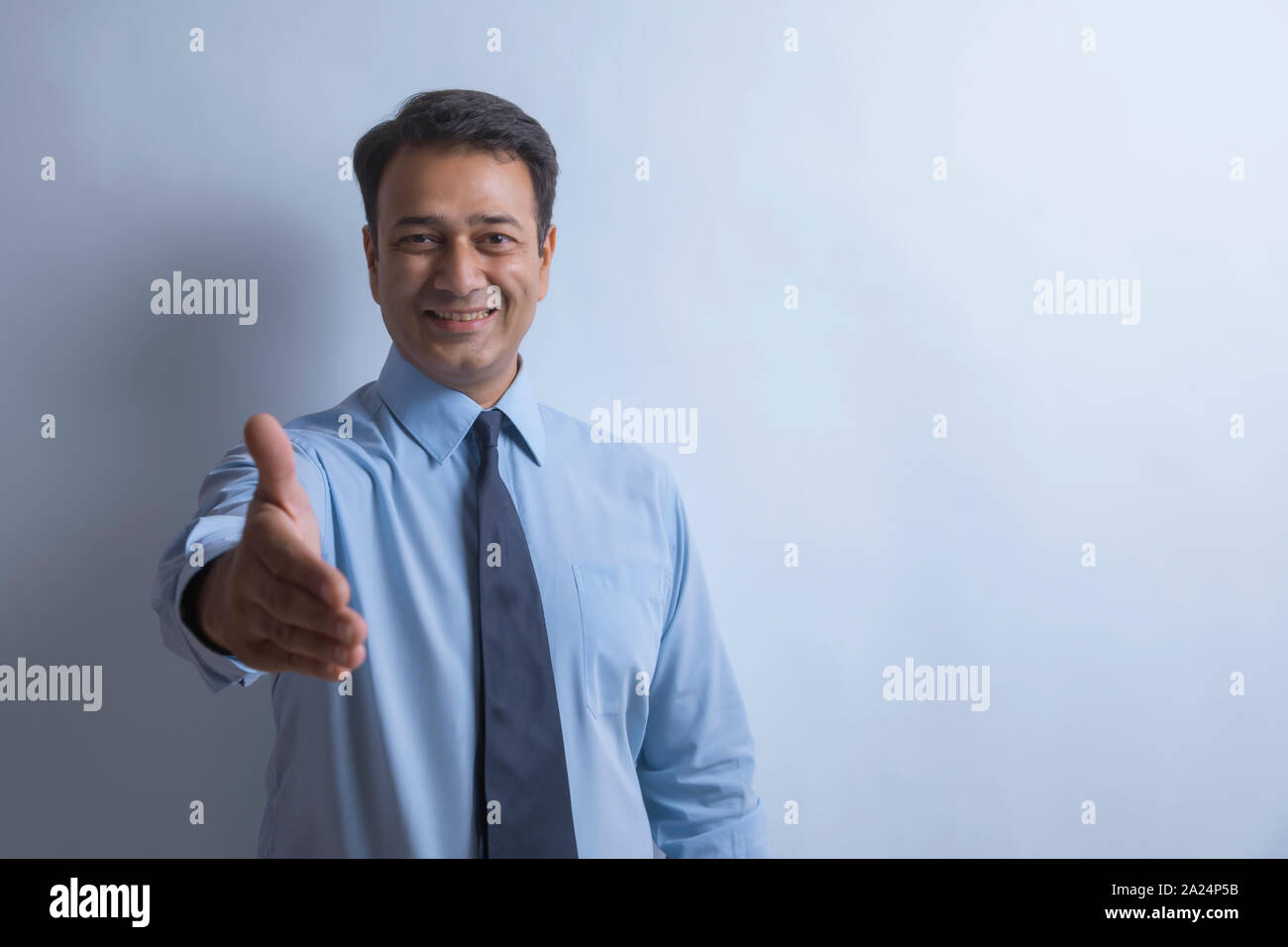 Ritratto di un imprenditore sorridente che si estende il suo braccio per agitare le mani Foto Stock