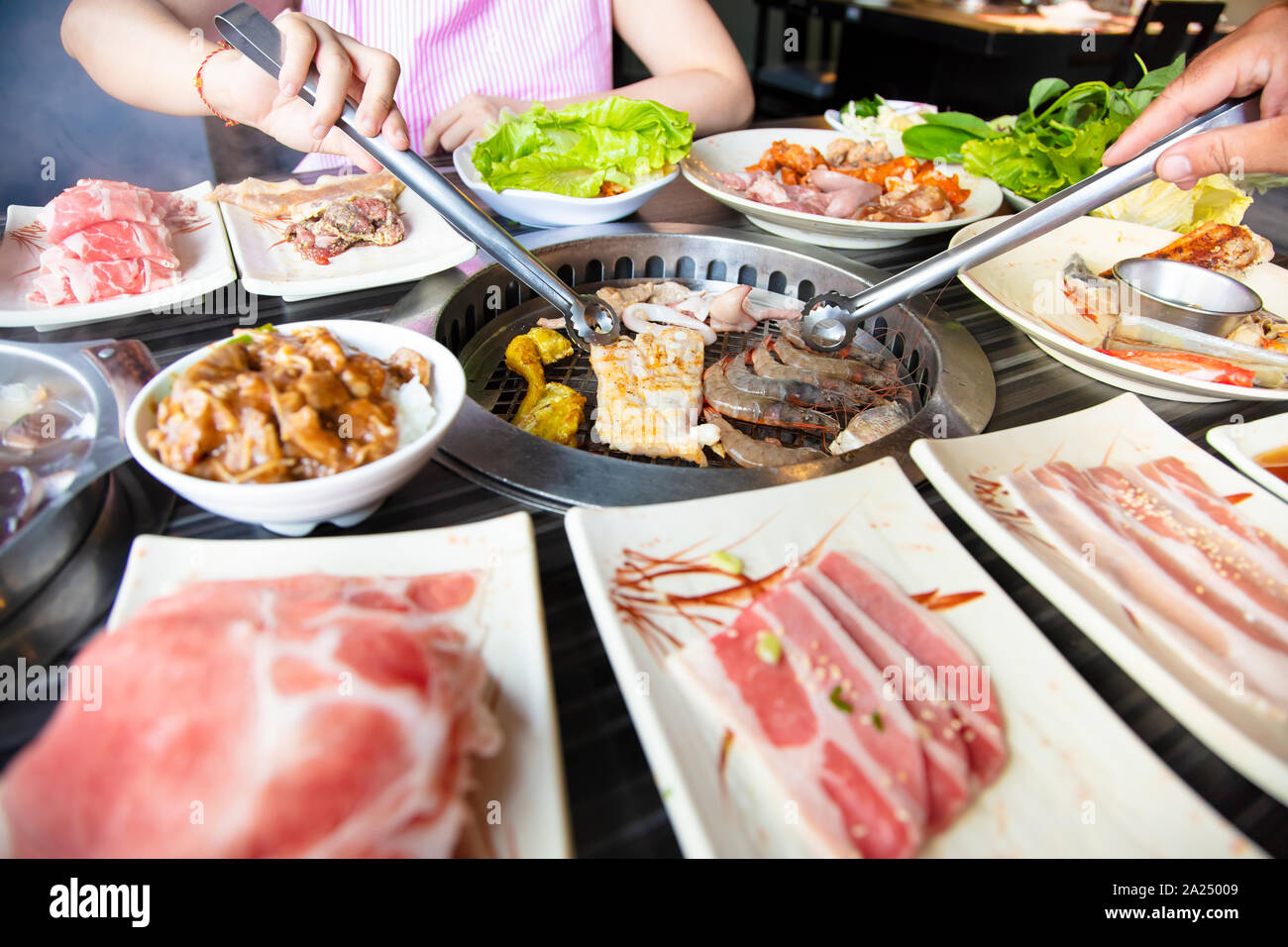 Persone mangiare barbecue di carni bovine nel ristorante Foto Stock